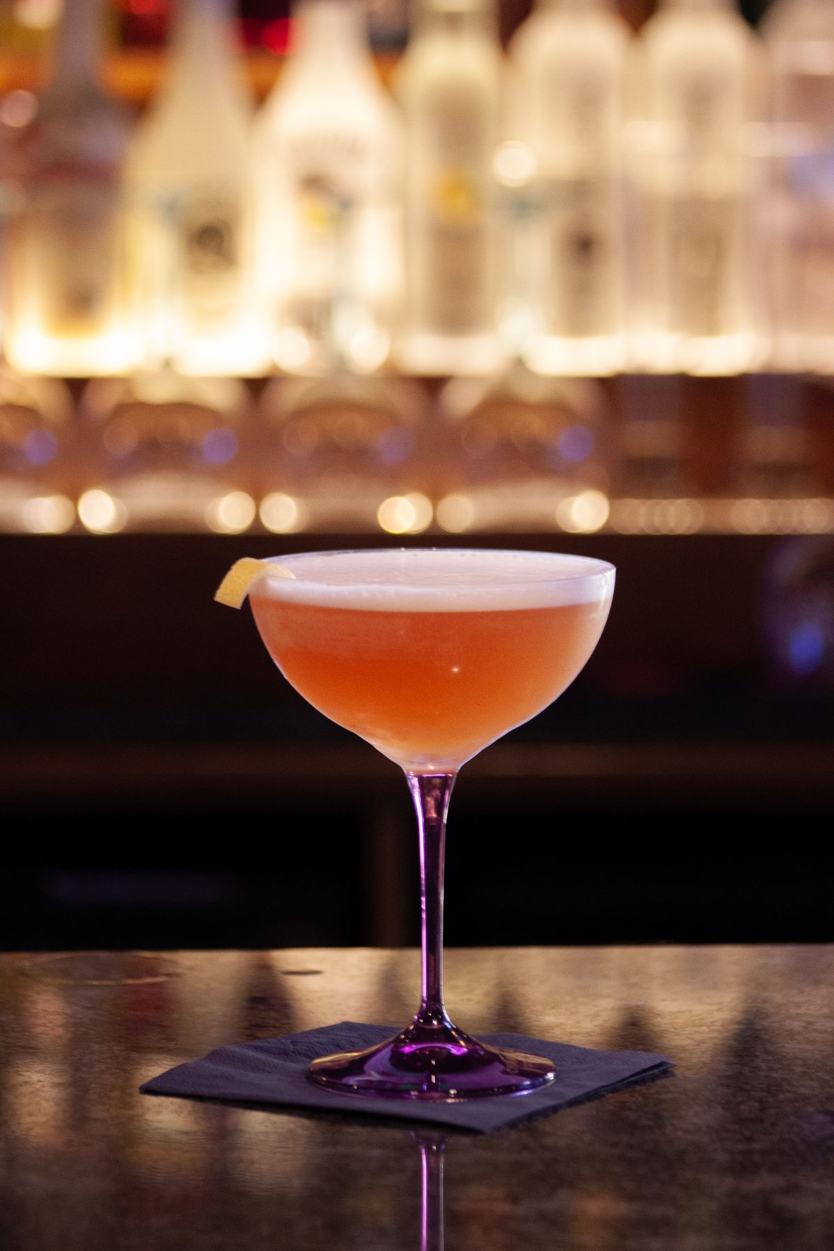 A coupe cocktail at a warmly lit bar