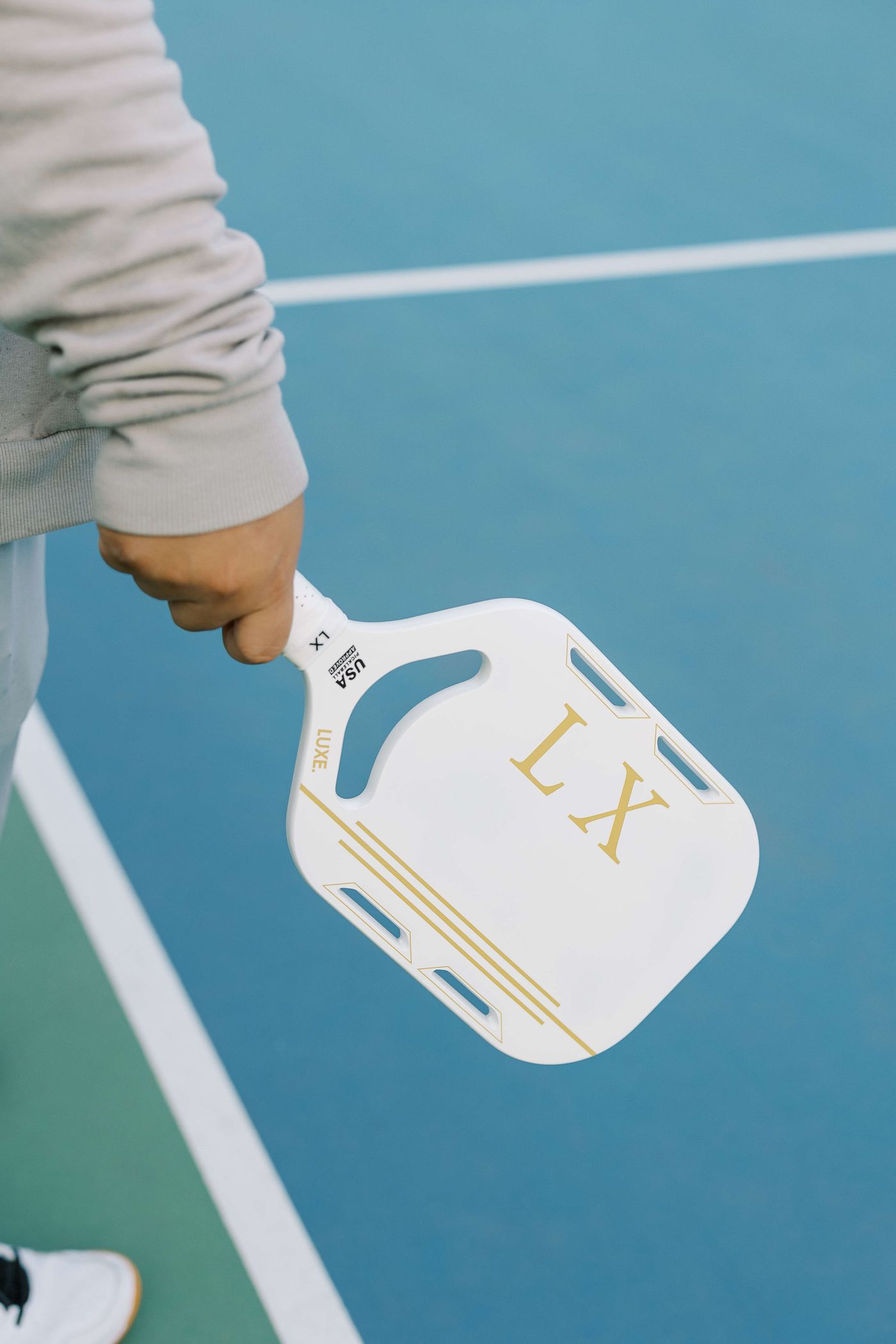 A player holding a pickleball paddle on a blue court